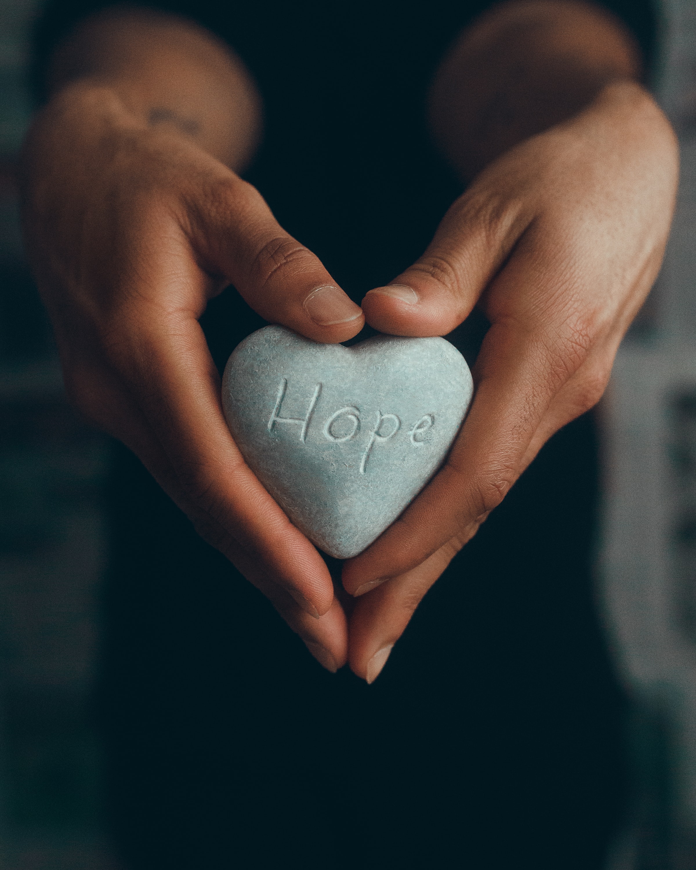 Hands holding heart rock